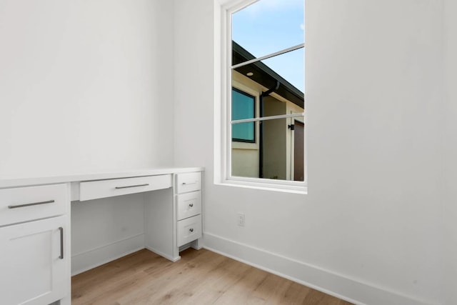 interior space with built in desk and light hardwood / wood-style flooring