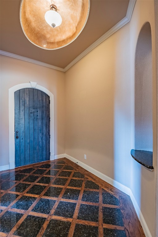 tiled spare room featuring ornamental molding and a tray ceiling