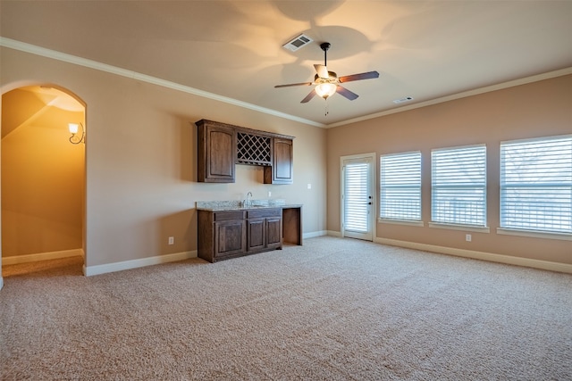 unfurnished living room with light carpet, ceiling fan, sink, and crown molding