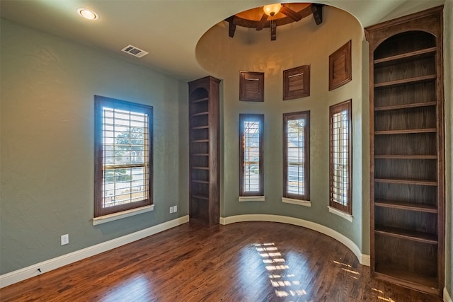 empty room featuring an inviting chandelier and dark wood-type flooring