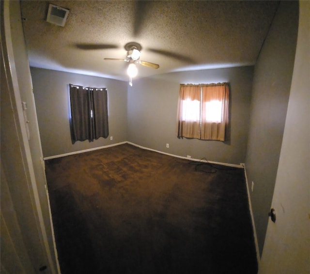 carpeted spare room with ceiling fan and a textured ceiling