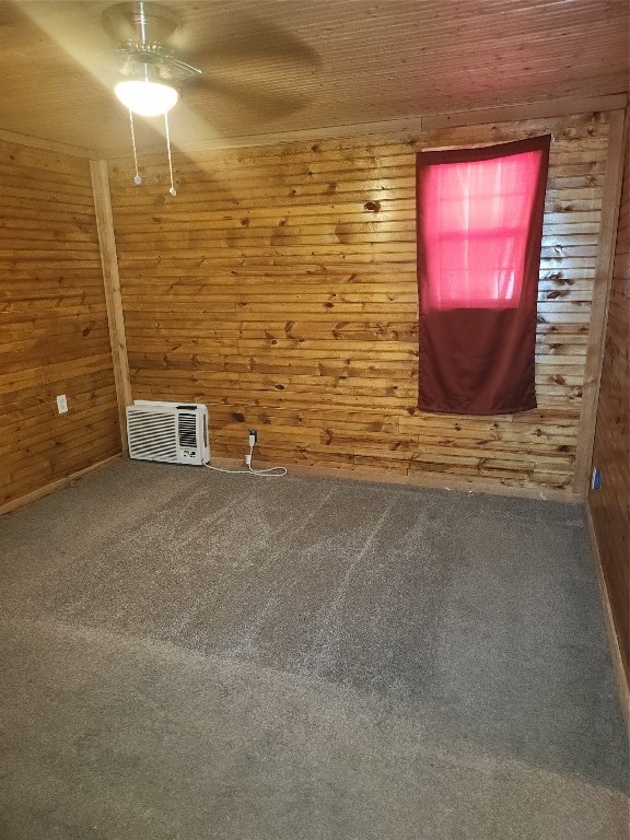 unfurnished room with wooden walls, ceiling fan, and carpet floors