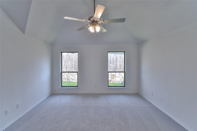 carpeted spare room featuring ceiling fan and vaulted ceiling