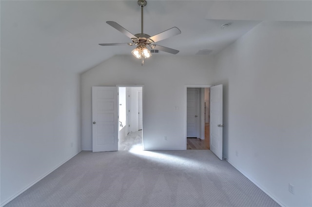 carpeted spare room featuring vaulted ceiling and ceiling fan