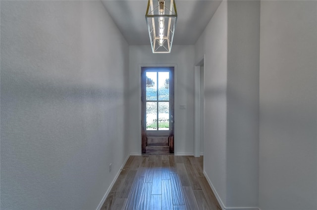 doorway to outside featuring hardwood / wood-style floors and a chandelier