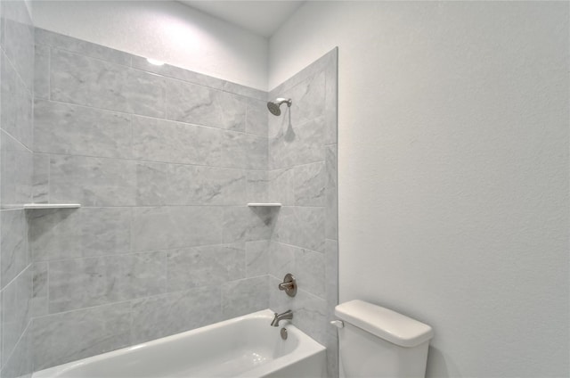 bathroom with toilet and tiled shower / bath