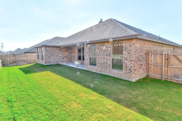 rear view of property featuring a lawn and a patio