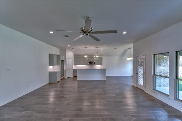 unfurnished living room with ceiling fan and dark wood-type flooring