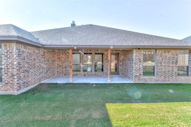 back of house with a lawn and a patio