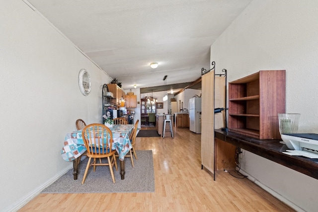 dining room with a notable chandelier and light wood-type flooring