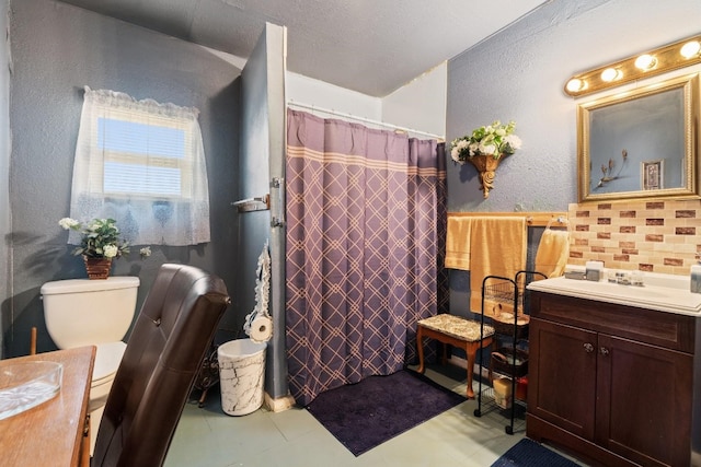 bathroom featuring backsplash, toilet, vanity, and tile floors