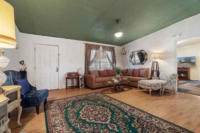 living room with light hardwood / wood-style floors and vaulted ceiling