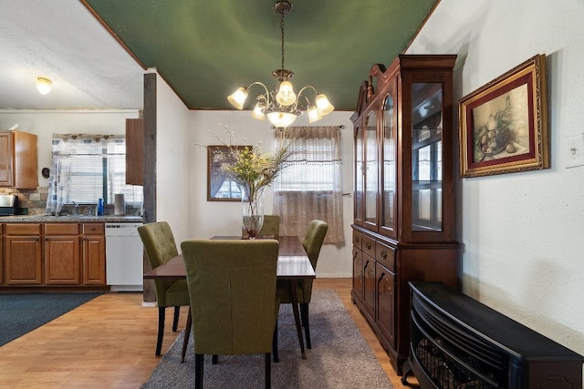 dining area with an inviting chandelier, sink, and light carpet