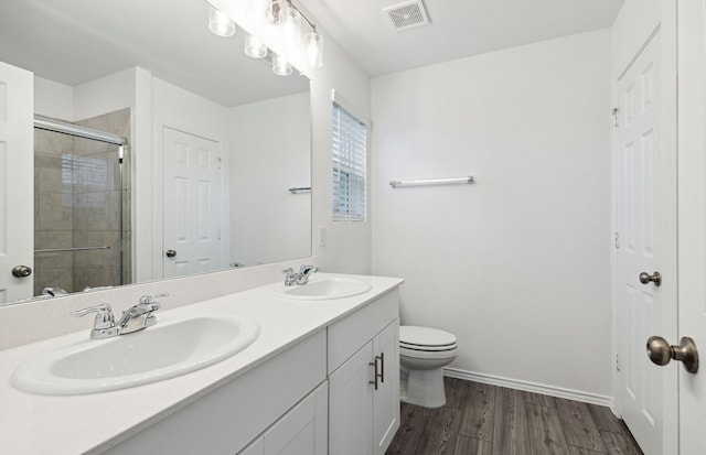 bathroom featuring vanity, hardwood / wood-style flooring, toilet, and an enclosed shower