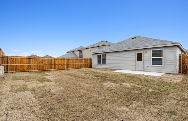 back of property with a patio area and a yard