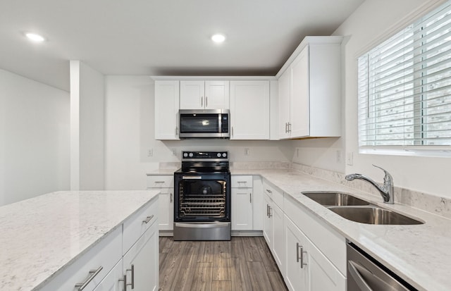 kitchen featuring white cabinets, sink, appliances with stainless steel finishes, and dark wood-type flooring