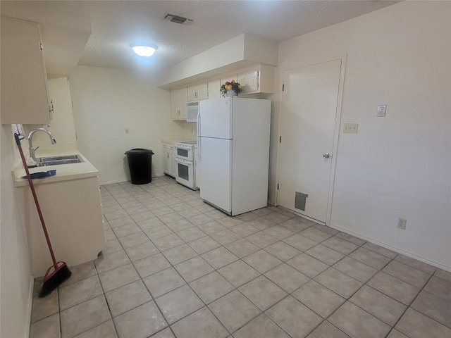 kitchen featuring light tile flooring, a textured ceiling, white appliances, white cabinets, and sink