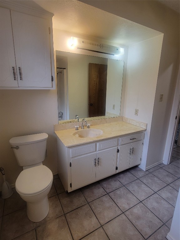 bathroom featuring toilet, tile flooring, and large vanity