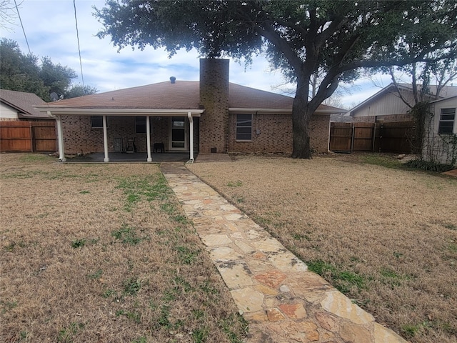 rear view of house with a yard and a patio