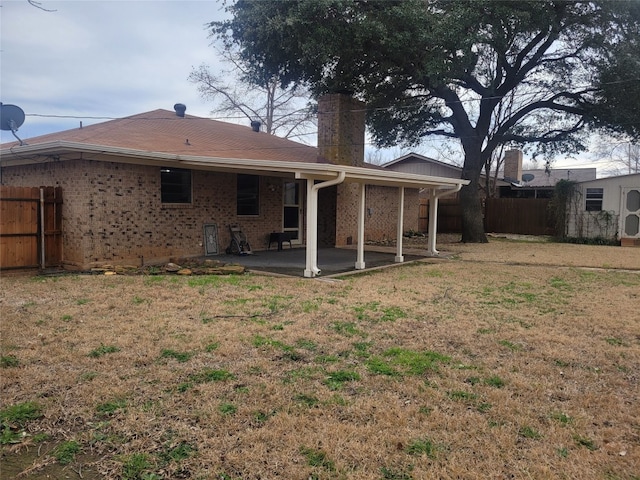 rear view of property featuring a yard and a patio