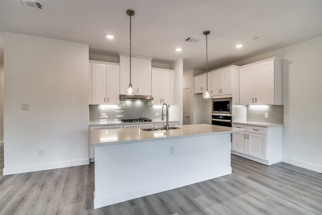 kitchen with appliances with stainless steel finishes, sink, white cabinets, and light wood-type flooring