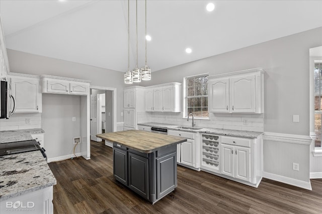 kitchen featuring dark hardwood / wood-style flooring, tasteful backsplash, a center island, and white cabinetry