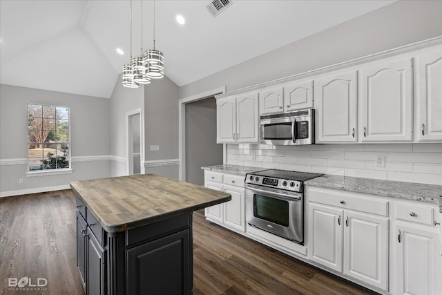 kitchen featuring dark wood-type flooring, appliances with stainless steel finishes, tasteful backsplash, white cabinets, and vaulted ceiling