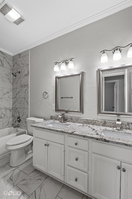 full bathroom featuring toilet, double vanity, ornamental molding, tiled shower / bath, and tile floors