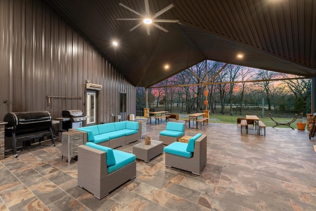 patio terrace at dusk with ceiling fan, a grill, outdoor lounge area, and outdoor dining space