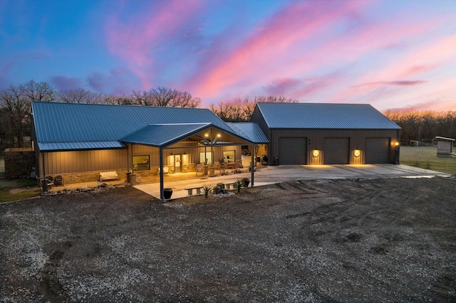 view of front facade featuring metal roof and driveway