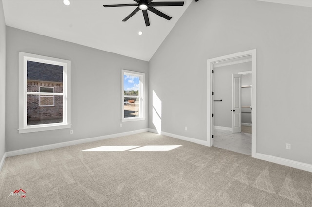 carpeted spare room with high vaulted ceiling and ceiling fan