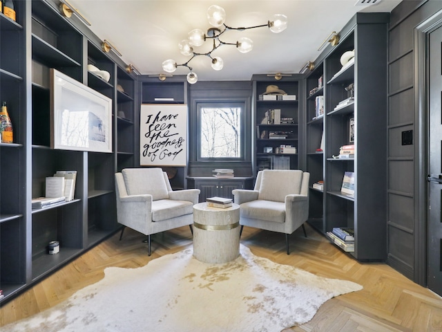 living area with light parquet floors and a notable chandelier