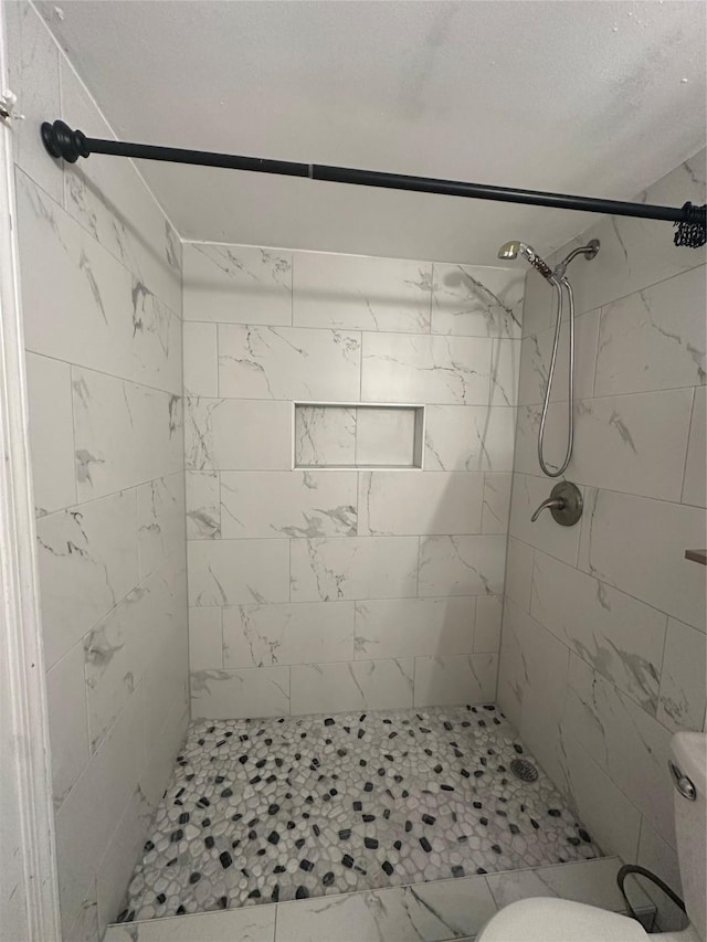 full bath featuring a stall shower and toilet