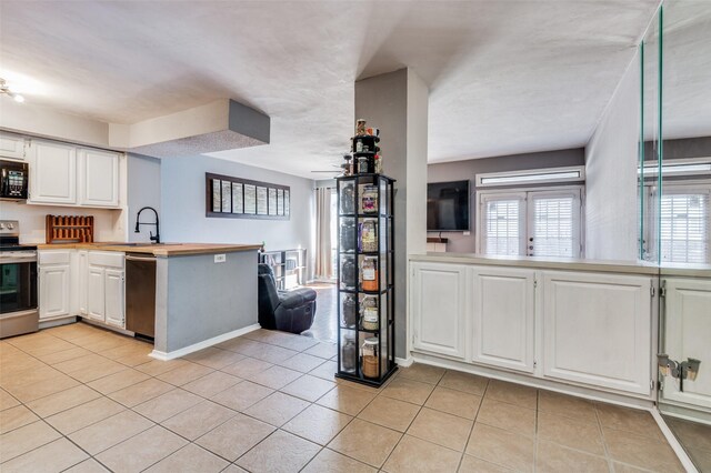 living room with a tiled fireplace, a wealth of natural light, and light hardwood / wood-style flooring