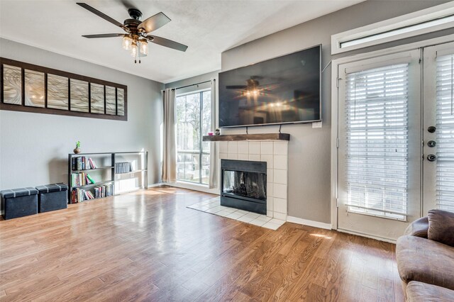 living room with hardwood / wood-style floors, ceiling fan, and a fireplace