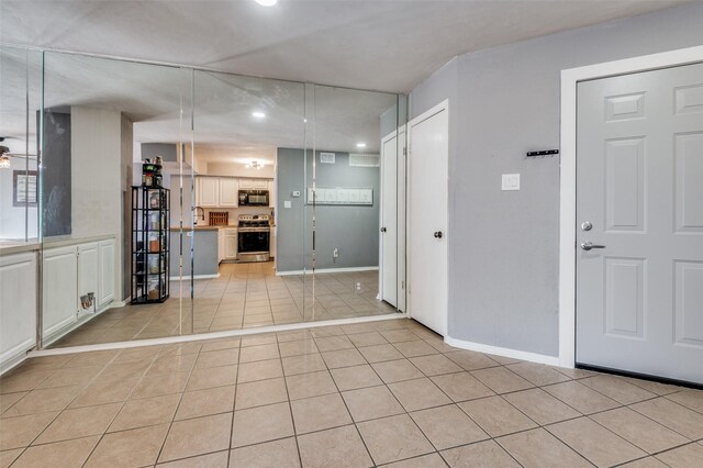 interior space featuring ceiling fan, sink, a fireplace, and light tile flooring