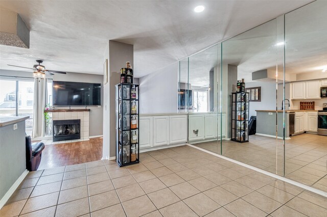 kitchen featuring stainless steel appliances, light tile floors, kitchen peninsula, white cabinetry, and french doors