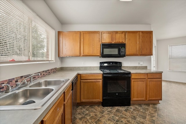 kitchen featuring dark tile flooring, black appliances, and sink