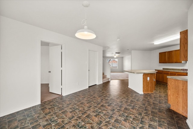 kitchen with pendant lighting, dark colored carpet, and a center island