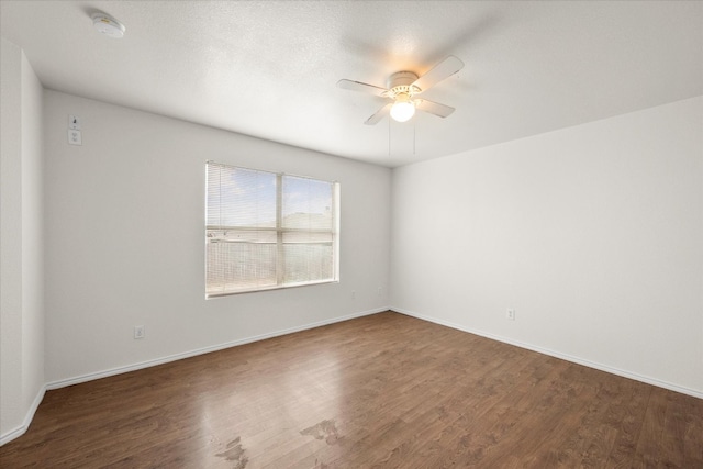 empty room featuring ceiling fan and dark hardwood / wood-style flooring