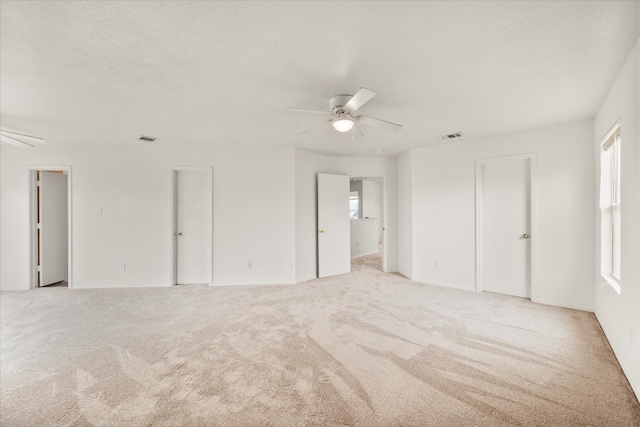 unfurnished bedroom featuring light colored carpet and ceiling fan