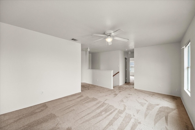 carpeted spare room featuring ceiling fan