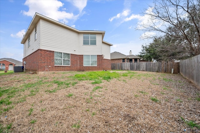 back of property with central air condition unit and a lawn