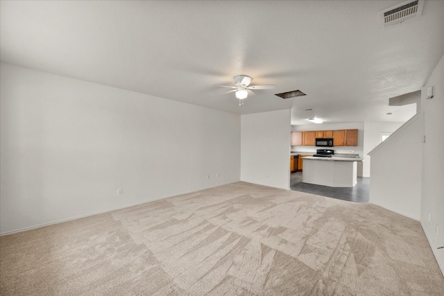 unfurnished living room featuring light colored carpet and ceiling fan