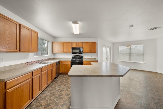 kitchen with decorative light fixtures, black appliances, sink, a center island, and dark tile flooring