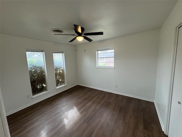 spare room with dark hardwood / wood-style floors and ceiling fan