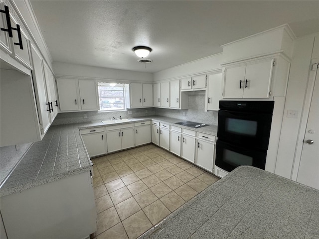 kitchen featuring white cabinets, tasteful backsplash, black appliances, and light tile floors