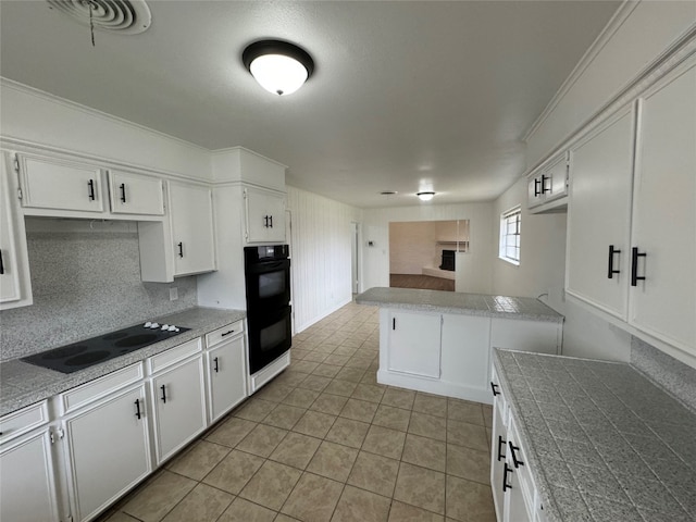 kitchen featuring white cabinets, black appliances, and light tile floors