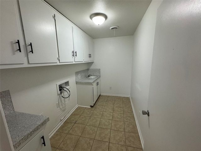 clothes washing area featuring cabinets, hookup for a washing machine, and light tile floors