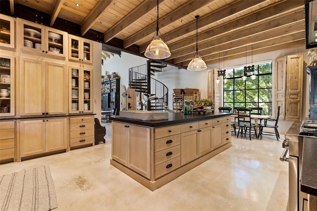 kitchen with light brown cabinets, beam ceiling, decorative light fixtures, and a center island